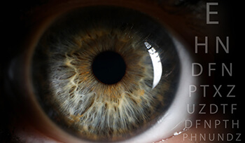 Closeup of an Eye Next to an Eye Chart