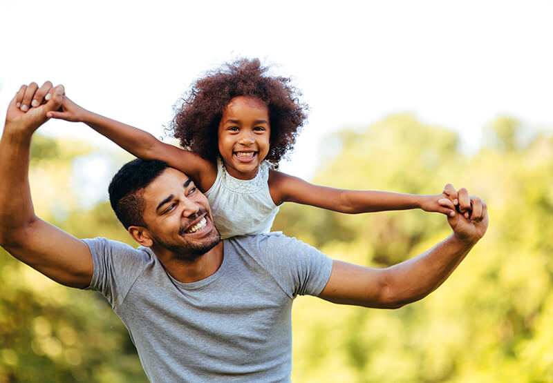 Happy Father and Daughter Playing in Park